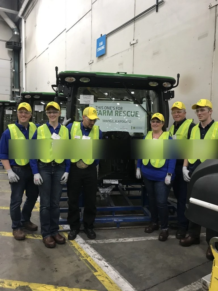 Gold Key tour group with a Farm Rescue tractor on the John Deere Waterloo Works assembly line