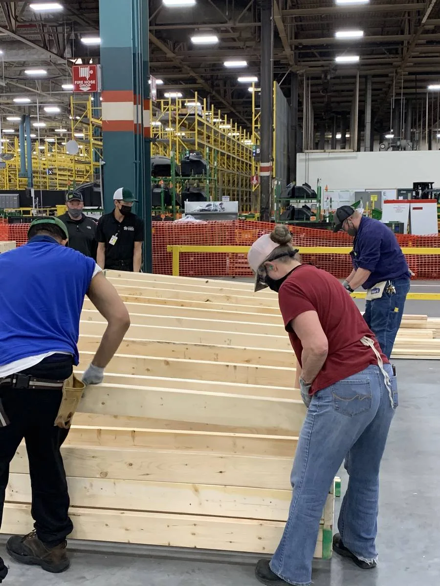 Employees building wall panels for Habitat for Humanity